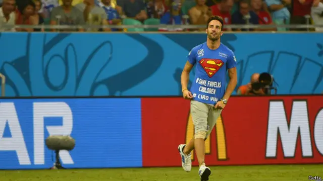 سپرمین کے لباس میں ملبوس فیری کی شرٹ پر دو پیغامات ’کچی آبادی کے بچوں کو بچاؤ‘ اور ’سائرس زندہ‘ لکھے تھے