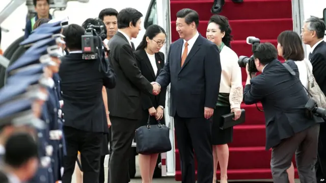 习近平（中）与尹炳世握手（3/7/2014）