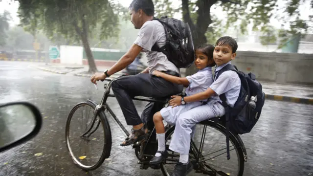 اچانک امڈ آنے والے بادل اور جل تھل مون سون کا خاصہ ہے اس تصویر میں نئی دہلی کی بارش میں سکول سے واپس لوٹتے بچوں کو بھیگا ہوا دیکھا جا سکتا ہے۔ 