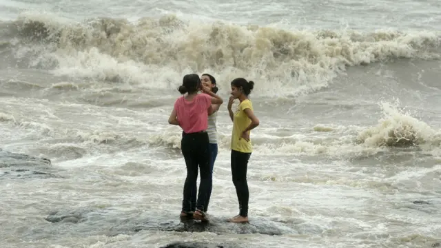 مون سون کی وجہ ممبئی میں درجہ حرارت تھوڑا گرا ہے۔ اسی خوشگوار بارش کے دوران موسم کا لطف لیتی ہوئی لڑکیاں۔ 