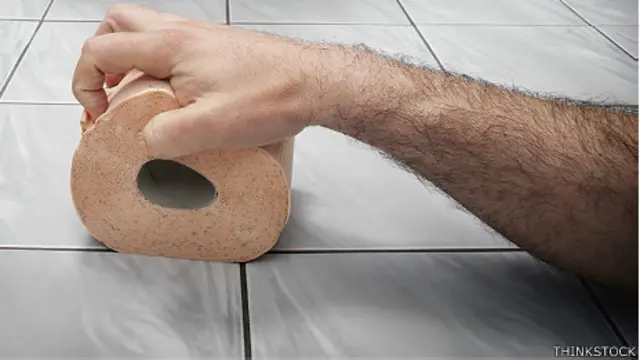 Hombre agarrando rollo de papel higiénico con dolor