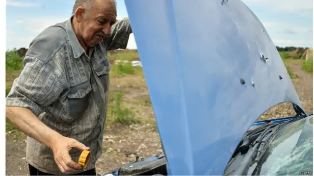 Під Слов'янськом: чоловік заглядає під капот, пробитий кулями