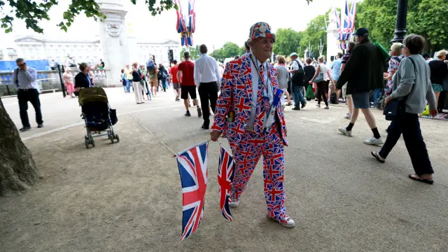 在围观的人群中有一名英国老人一穿英国国旗打扮，令人眼前一亮。