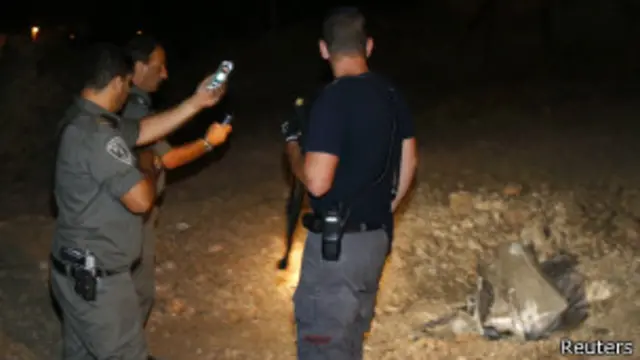 Policías israelíes, cerca de Jerusalén, junto a los restos de un cohete lanzado desde Gaza.