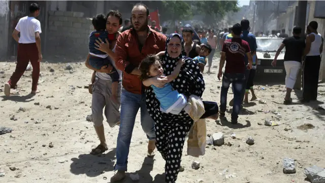 فلسطينيون يهرعون بعيدا عن منزل تعرض لغارة جوية شنتها اسرائيل.