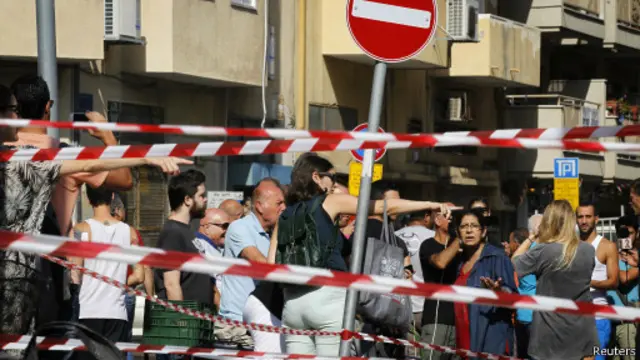 الإسرائيليون يشاهدون حطام صاروخ اعترضته منظومة القبة الحديدية قرب ضواحي تل أبيب.