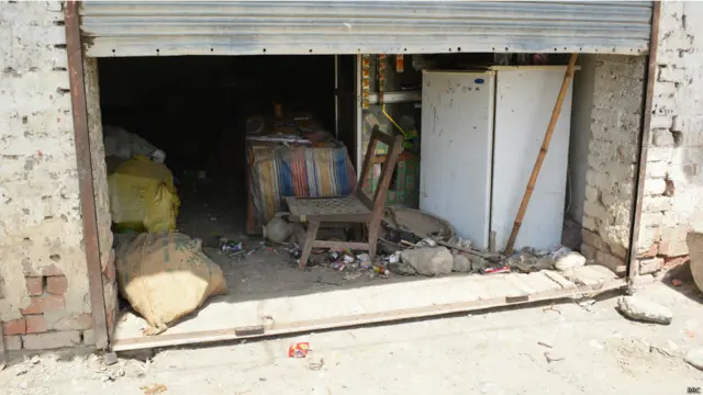 میران شاہ بازار کا ایک منظر۔ بہت سی دکانوں کے آدھے شٹر بند تھے اور ایسا محسوس ہوتا ہے جیسے دکاندار جلدی میں آدھی دکانیں کھلی چھوڑ کر چلےگئے۔