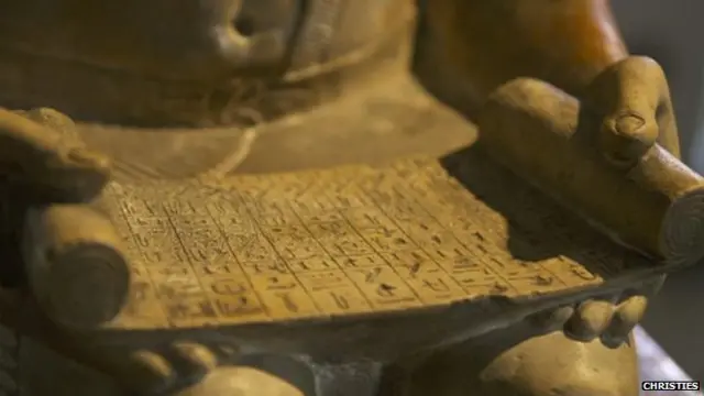 مخطوطة في يد التمثال