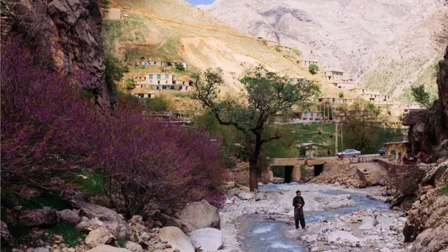 ایرانی کردستان کی وادی ہورمان میں ایک شخص دریا میں نماز ادا کر رہا ہے۔