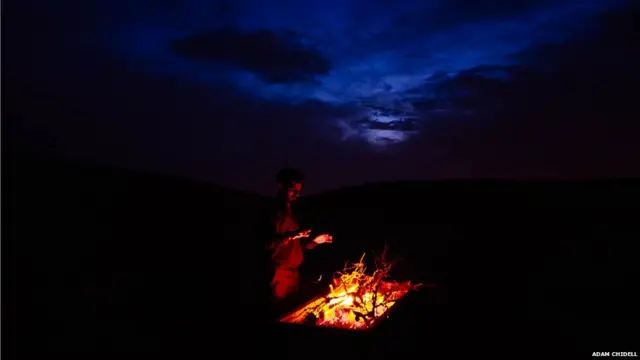 اصفہان کے نزدیک واقع صحرا میں شام کو ایک شخص آگ تاپ رہا ہے۔ یہ صحرا اپنے ریتلے ٹیلوں کے لیے مشہور اور مقبول سیاحتی مقام ہے۔