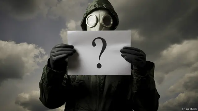 Мужчина в комбинезоне химзащиты с вопросом в руках