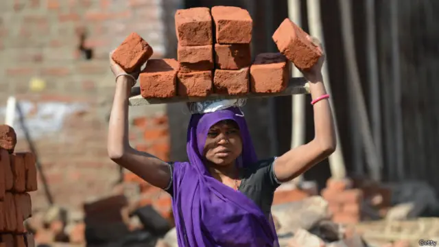 Mujer acarrea ladrillos