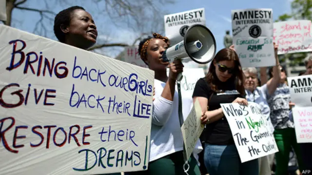 ‘අපේ දැරියන් නැවත ගෙන දෙන්න’ පාඨය යොදා ගනිමින් උද්ඝෝෂණය කරන පිරිස් 