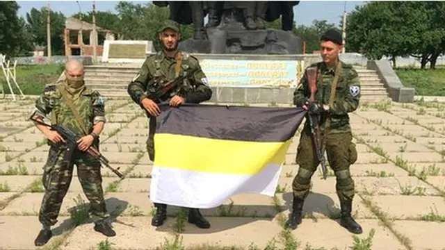 卢甘斯克亲俄武装的俄国志愿兵展示代表亲俄武装的旗帜。