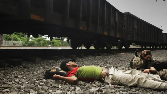 Migrantes tomando un descanso cerca del ferrocarril