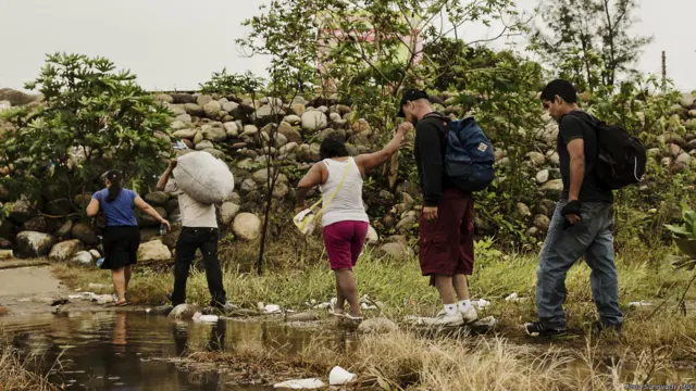 Migrantes cruzan una cañada