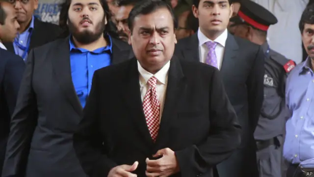 مکیش امبانی کے پشت پر نیلے شرٹ میں ان کے بیٹے آکاش امبانی کو دیکھا جا سکتا ہے