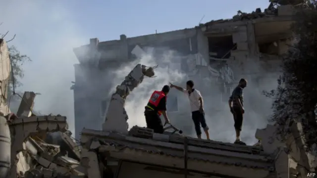 Пожарники пытаются потушить пожар после авиаудара израильтян