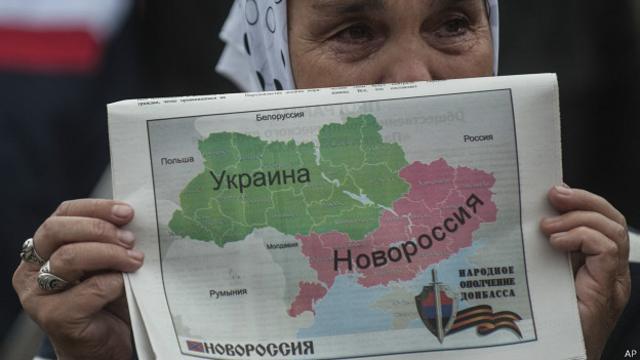 Женщина держит карту Украины, разделенную на две части