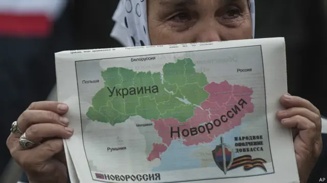 Женщина держит карту Украины, разделенную на две части