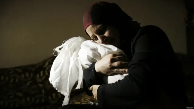 En la imagen, Netream Netzleam sostiene el cuerpo de su hija Razel. Crédito: Reuters. 