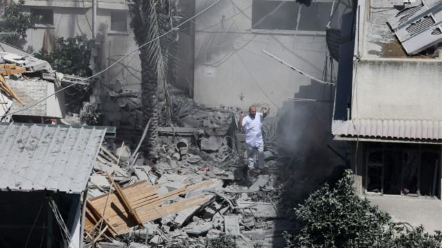 En la imagen, un hombre espera con los brazos levantados sobre los esconbros de un edificio en la ciudad de Gaza. Crédito: AP.
