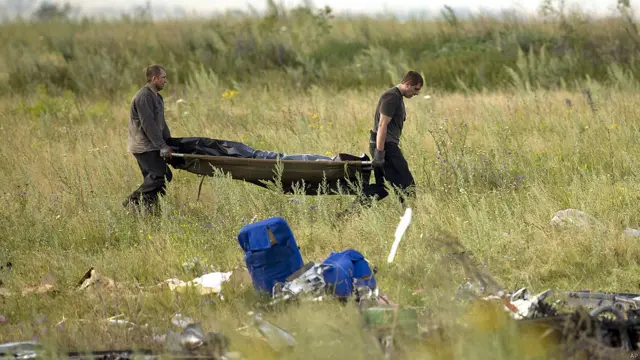 Dos rescatistas llevan el cadáver de una víctima
