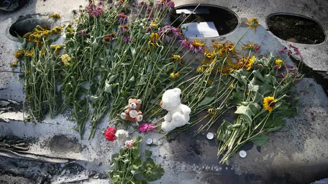 Flores y recuerdos sobre los restos del avión