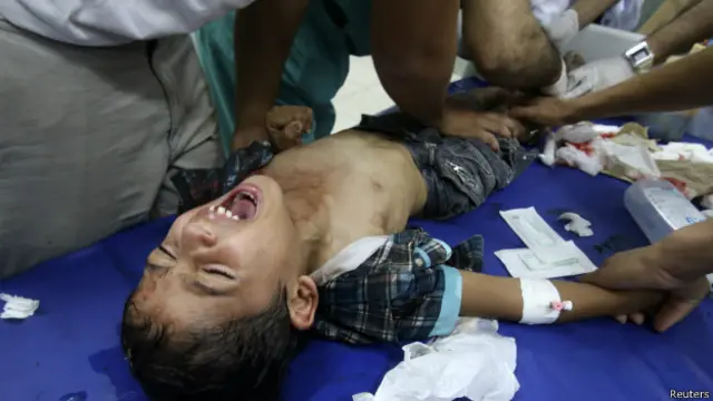 Menino é atendido por paramédicos após bombardeio de hospital em Gaza (Reuters)