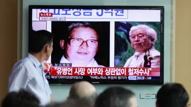 韩国首尔火车站民众收看电视新闻报道俞炳彦死亡的消息（22/7/2014）