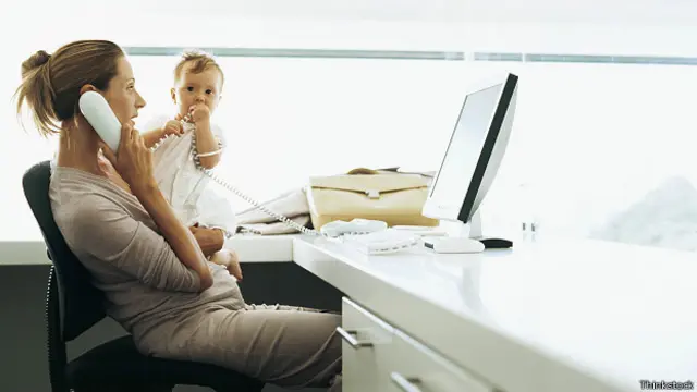 Женщина разговаривает в офисе по телефону, рядом ребенок