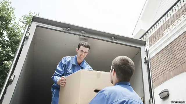 Грузчики грузят коробки в грузовик