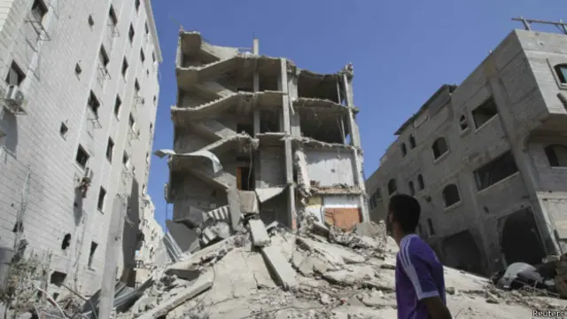 Палестинец смотрит на руины жилого дома в Газе