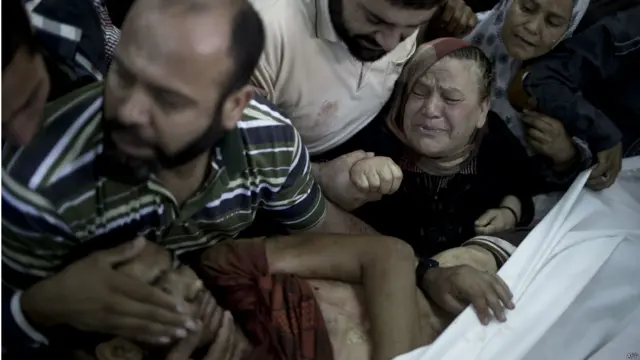 زنی عزادار که یکی از نزدیکانش را در حمله اسرائیل به مدرسه‌ سازمان ملل از دست داده است. تاکنون بیش از ٧٥٠ فلسطینی در این حملات کشته شدند