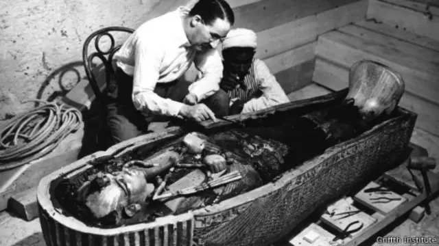 هوارد كارتر ومساعد له يفحص التابوت الداخلي لتوت عنخ آمون