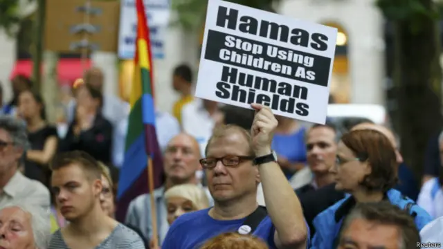 Manifestante pró-Israel segura cartaz dizendo "Hamas, pare de usar crianças como escudo humano" em Berlim | Foto: Reuters