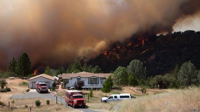 Un equipo de bomberos protege una casa evacuada en las cercanías de Plymouth, California. Detrás, avanza el “Incendio de Arena”. REUTERS 