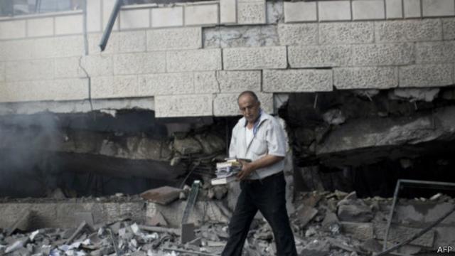 مواطن فلسطيني يجمع ما استطاع جمعه من محتويات أحد المساجد المدمرة.