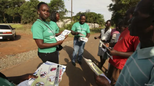 Сотрудники благотворительной организации раздают брошюры о лихорадке Эбола в Либерии