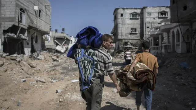 Ateşkes yürürlükteyken Gazze Şeridi'nin Huzaa kentinde yaşayan Filistinliler enkaza dönen bölgede eşyalarını aradı. (EPA)