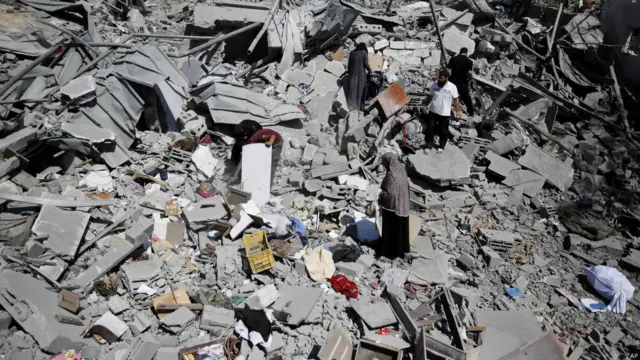 İsrail'in saldırdığı Beyt Hanun'da evleri yerle bir olan Filistinliler, enkaz arasında eşyalarını arıyor. (AP)