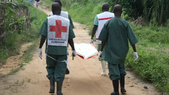 Trabajadores de la salud cargando un cadáver