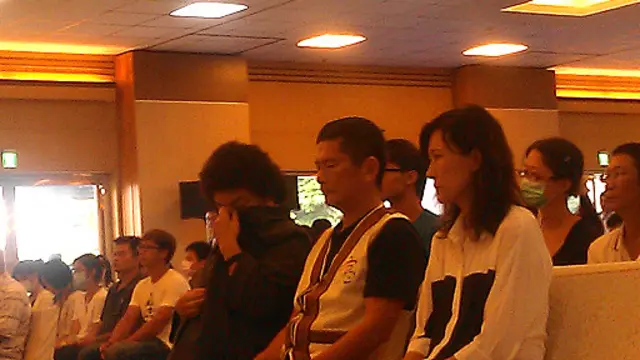 高雄市长陈菊在罹难者法会上拭泪。 