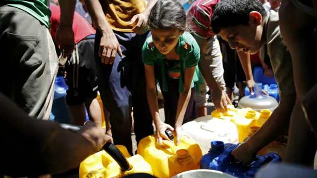 این کودکان پس از حمله به مدرسه‌ای در رفح مشغول جمع‌آوری آب هستند. سازمان ملل می‌گوید آب شهری در بیشتر نقاط غزه قطع شده است