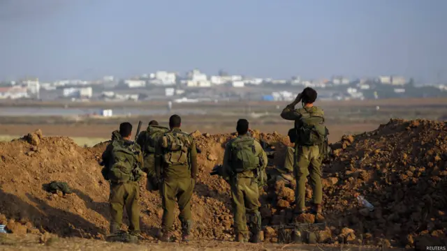 سربازان اسرائیلی در حال تماشای غزه. بیش از ۱۷۰۰ فلسطینی و ۶۶ اسرائیلی در این حملات کشته شدند