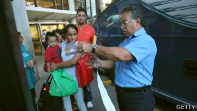 Madre y niño esperan para abordar autobús tras ser liberados de un centro de detención en EE.UU.