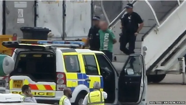 持槍警官在飛機安全降落之後登上了飛機，並從機上帶走一名男子。