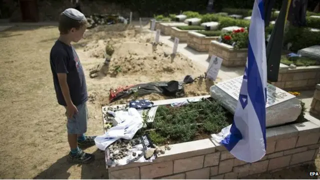 Seorang bocah Israel berada di depan makam tentara Israel yang tewas akibat serangan roket Hamas.