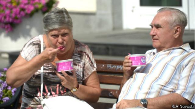 Пенсионеры едят мороженое на Кузнецком Мосту в Москве 3 августа 2014 года