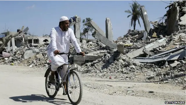 مرد فلسطینی در جنوب غزه از کنار خانه های ویرانشده می گذرد